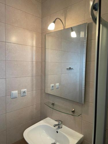 a bathroom with a sink and a mirror at Centrum Rooms in Kallithea Halkidikis