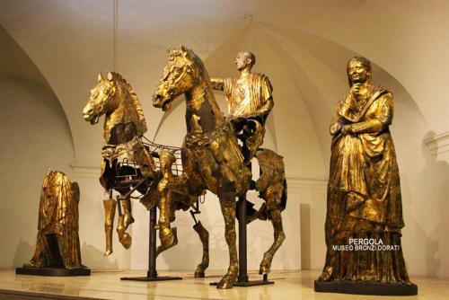 a golden statue of a man on a horse in a museum at Camera con vista in Fossombrone
