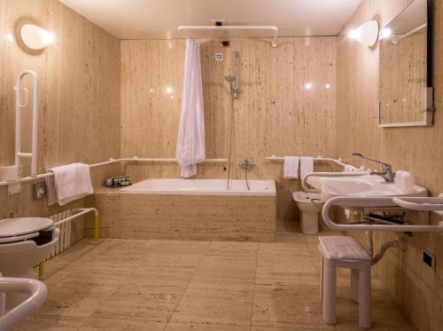 a bathroom with a tub and a toilet and a sink at Grande Albergo Roma in Piacenza