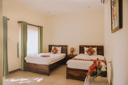 a bedroom with two beds and a window at Xin Chao Hotel in Mui Ne