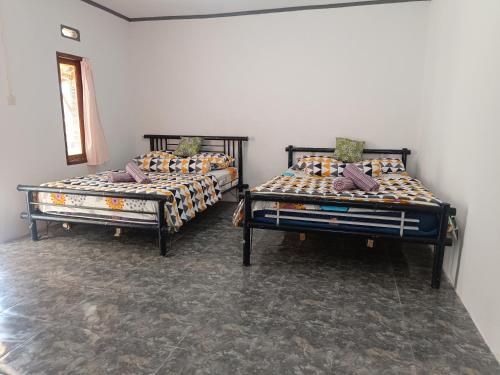 2 Betten nebeneinander in einem Zimmer in der Unterkunft Tetebatu Terrace Homestay in Tetebatu