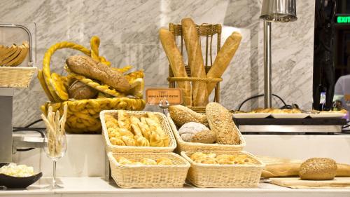 a buffet with baskets of bread and pastries on a table at Tang Palace Hotel in Accra