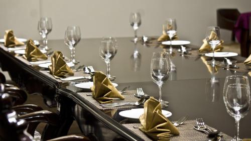 a long table with wine glasses and napkins at Tang Palace Hotel in Accra