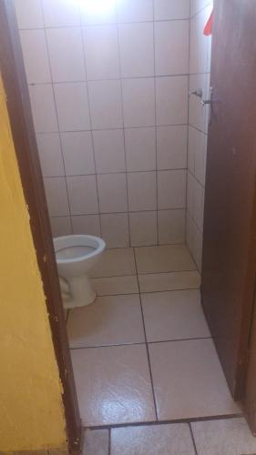 a bathroom with a toilet and a tiled floor at Casa DIMAS in São Pedro