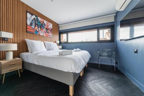 une chambre avec un grand lit dans une pièce bleue dans l'établissement Maison d'Architecte aux Portes de Paris, à LʼHay-les-Roses