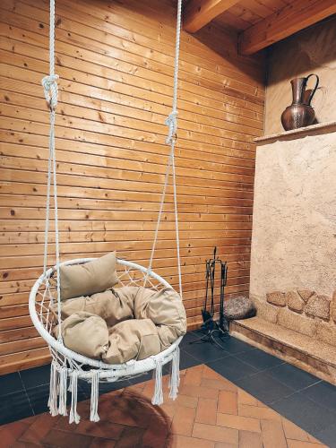 a hanging chair with a pillow in a room at Vila Ambasada in Šventoji