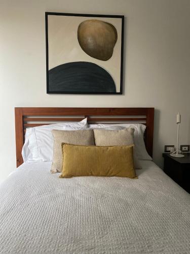 a bedroom with a bed with a painting on the wall at Apartamento moderno 2 habitaciones y 2 baños area Cayala y Embajada USA in Guatemala