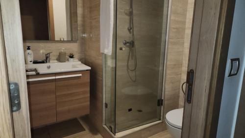 a bathroom with a shower and a toilet and a sink at Plage dès nations 2 bedroom apartment with backyard view in Sidi Bouqnadel