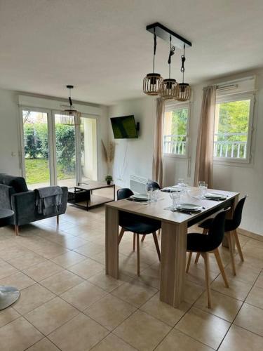un salon avec une table et des chaises dans l'établissement T3 - Spacieux et au calme - Avec jardin privatif, à Saint-Laurent-de-Médoc