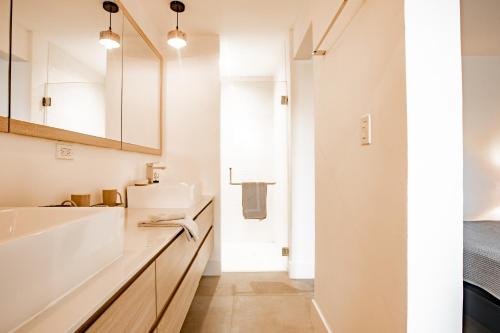a white bathroom with a sink and a mirror at Ocean View Apartment - Blue Venao in Playa Venao