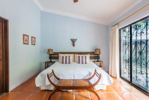 a bedroom with a bed and a large window at Casona de Elefantes Boutique Hotel in Cuernavaca