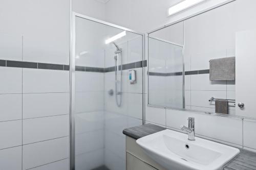布魯姆的住宿－Cable Beach Apartments，白色的浴室设有水槽和淋浴。