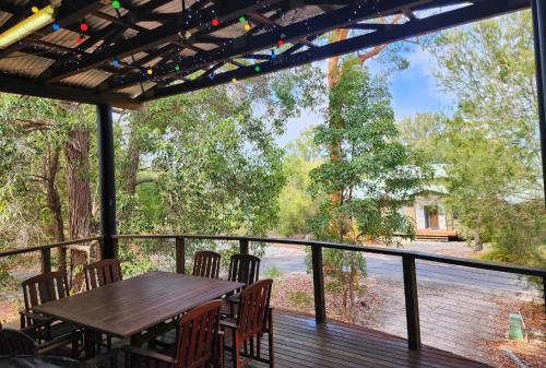 a deck with a table and chairs and a view at EUROLIE ON HIGH at Kingfisher Bay Fraser Island in Kingfisher Bay