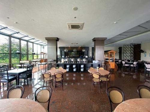 um restaurante com mesas e cadeiras num quarto em Hotel Eastern Bojonegoro em Bojonegoro