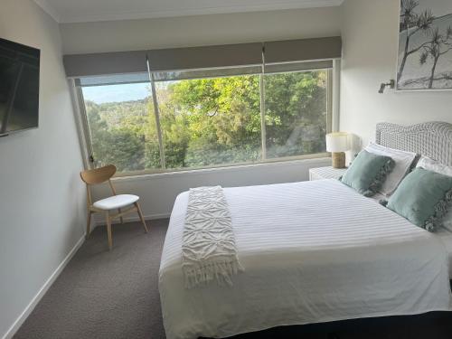 a bedroom with a large bed and a window at BlueWater Apartments in Merimbula