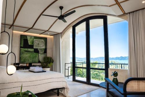 een slaapkamer met een bed en een groot raam bij Oculus Bali in Kintamani
