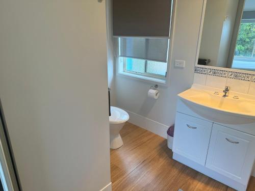 a bathroom with a sink and a toilet at BlueWater Apartments in Merimbula