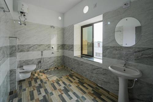 een badkamer met een wastafel en een spiegel bij Hotel Grace Premium Bhubaneswar Near Khandagiri - Excellent Quality Room - Couple Friendly in Bhubaneshwar