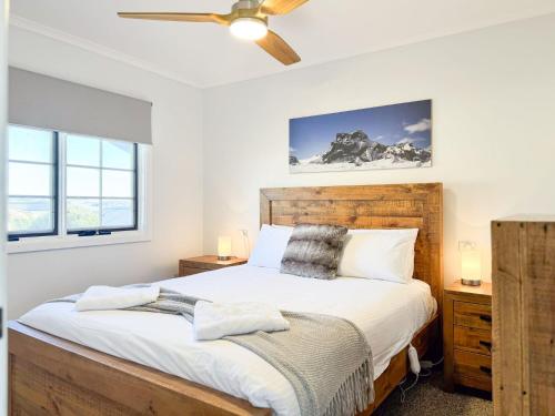 a bedroom with a bed and a ceiling fan at Karoonda Lodge in Jindabyne