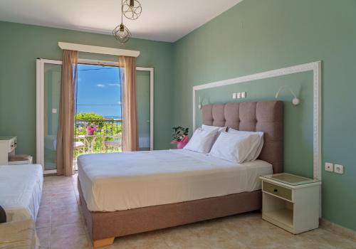 a bedroom with a large bed and a balcony at Diona Studios in Lourdhata