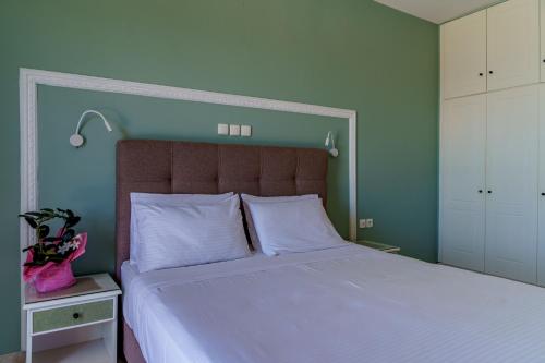 a bedroom with a large bed with blue walls at Diona Studios in Lourdhata