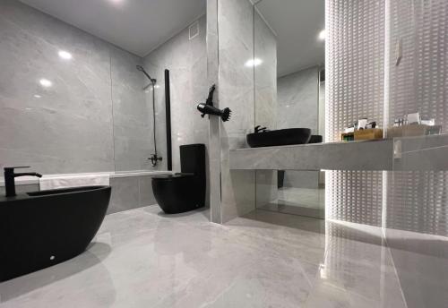 a bathroom with two sinks and a bath tub and a toilet at Hotel Alfonso IX in Sarria