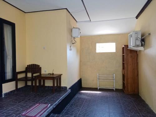 a room with a table and a chair and a tv at Scuba Tribe Bali dive-resort in Tulamben