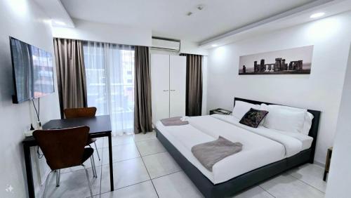 a hotel room with a bed and a desk and a bed and a desk at Tropical Garden A Studio in Pattaya South