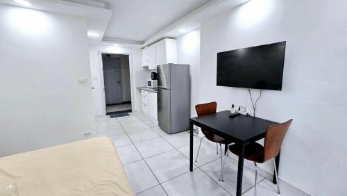 a kitchen with a table and a television on a wall at Tropical Garden A Studio in Pattaya South