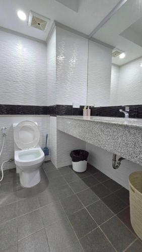 a bathroom with a toilet and a sink and a mirror at Tropical Garden A Studio in Pattaya South