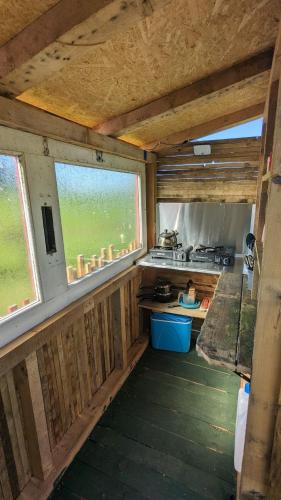 an inside view of a kitchen with two windows at Belle Village, non electric ,Rent a bell tent, BEDDING NOT SUPPLIED in Narberth