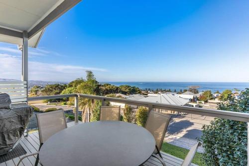 a table and chairs on a balcony with a view of the ocean at Oceanview at Encounter - 4BR Family Escape in Encounter Bay