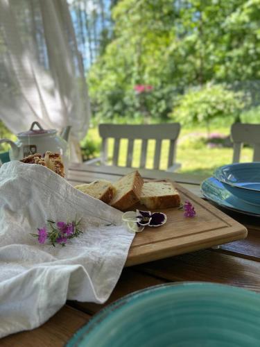 a wooden cutting board with bread on a table at Łąckówka Mazury in Świętajno