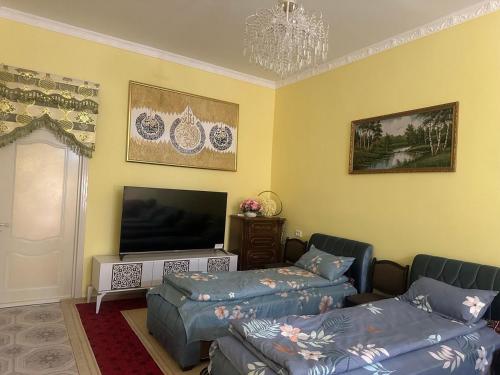 ein Wohnzimmer mit 2 Sofas und einem Flachbild-TV in der Unterkunft Lovely home in Urganch