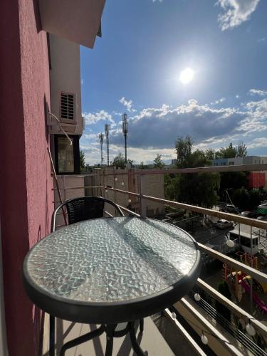 a glass table on the balcony of a building at Brown Aparts in Chişinău