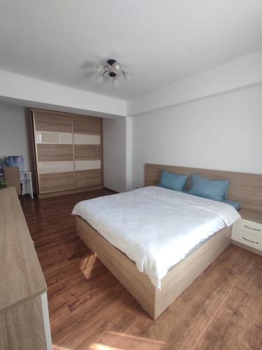 a bedroom with a large white bed with blue pillows at Brown Aparts in Chişinău