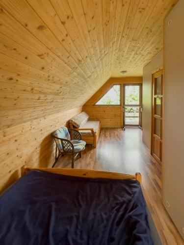 a room with a large wooden ceiling and a bed at Domek nad Jeziorem in Ryn