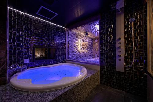 a large bathroom with a tub with a fireplace at Hotel P'sResort Adults only 大人専用 in Tokyo