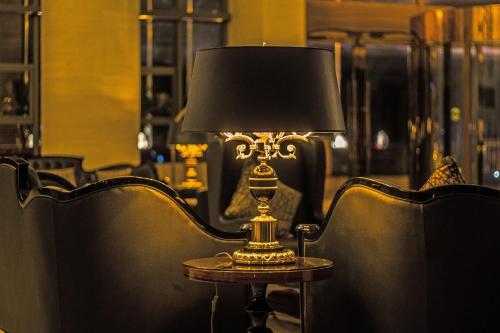 a lamp sitting on a table next to chairs at Tang Palace Hotel in Accra