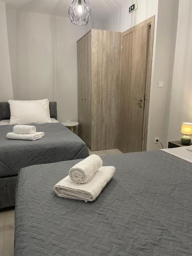 two beds in a room with two towels on them at TERRA HOMERICA in Chios