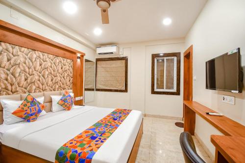 a bedroom with a large bed and a television at FabHotel Dreamworld Residency - Near bisarjan ghat in Kolkata