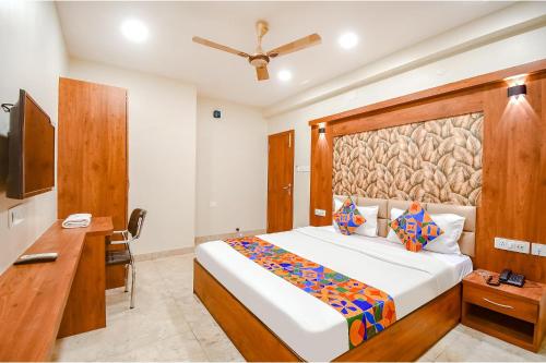 a bedroom with a bed and a desk and a television at FabHotel Dream World Residency in Kolkata