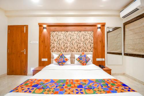 a bedroom with a large bed with a colorful bedspread at FabHotel Dream World Residency in Kolkata
