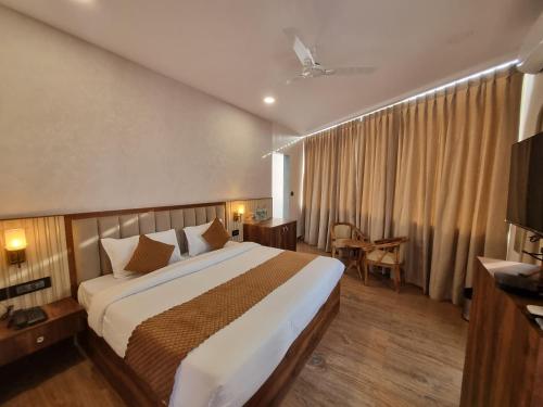 Cette chambre comprend un grand lit et une télévision. dans l'établissement The Robin- A Boutique Hotel, à Jaipur
