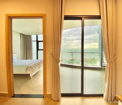 Lfamily Ocean view Apartment 91m2 - ARIA Vung Tau Private Beach Resort, căn hộ Aria Vũng Tàu 91 m2 view biển, bãi biển riêng في فنغ تاو: غرفة نوم مع سرير وإطلالة على المحيط
