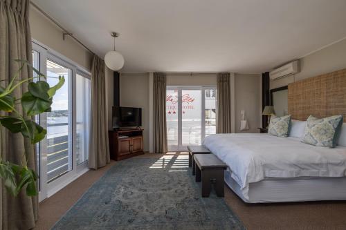 a hotel room with a large bed and a balcony at The Lofts Boutique Hotel in Knysna