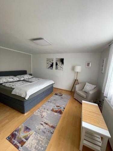 a bedroom with a bed and a couch and a table at InNatura Velden in Velden am Wörthersee