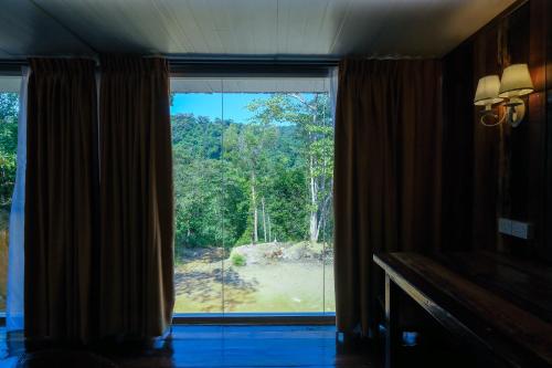 a room with a window with a view of a forest at Woodcookies Guesthouse in Pangkor