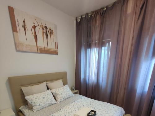 a bedroom with a bed and a window with curtains at Downtown Studio in Bucharest