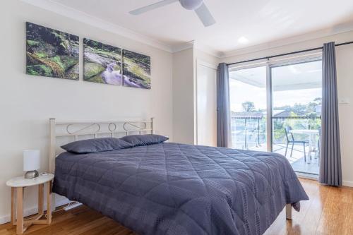 a bedroom with a bed and a large window at Unbeatable Waterfront Location in Sussex Inlet